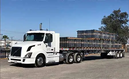 A flatbed semi truck loaded with underlayment from Fontana Paper Mills